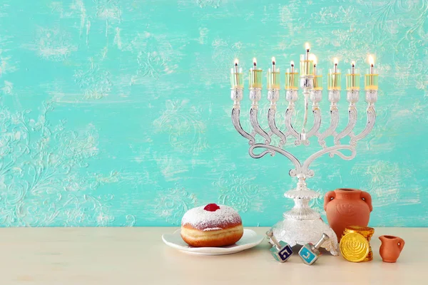 Imagen religiosa de vacaciones judías fondo Hanukkah con menorah (candelabros tradicionales), peonza y rosquilla —  Fotos de Stock