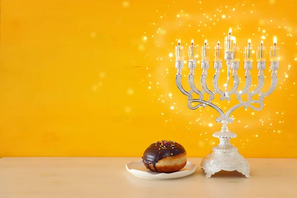 Religion image of jewish holiday Hanukkah background with menorah (traditional candelabra) and doughnut — Stock Photo, Image