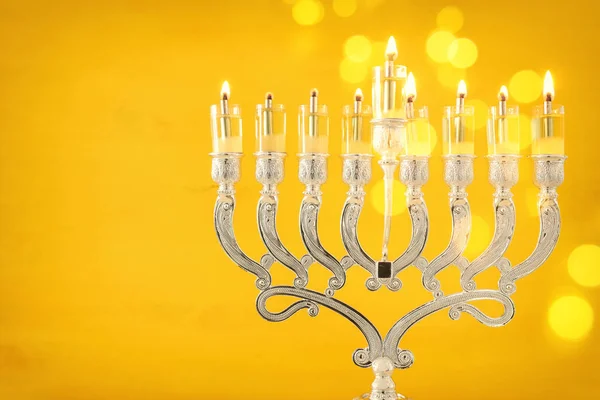 Religionsbild des jüdischen Feiertags Chanukka Hintergrund mit Menora (traditioneller Leuchter) und Ölkerzen über gelbem Hintergrund — Stockfoto