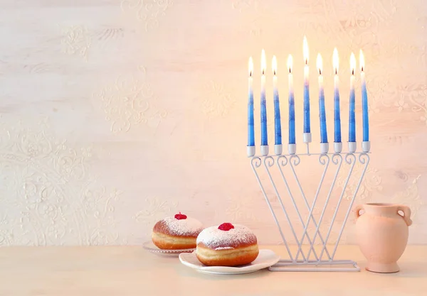 犹太节日的宗教形象Hanukkah背景与menorah (传统烛台)和白底甜甜圈 — 图库照片