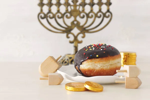 Religionsbild des jüdischen Feiertags Chanukka Hintergrund mit Menora (traditioneller Leuchter), Kreisel und Donut über Pastell Hintergrund — Stockfoto