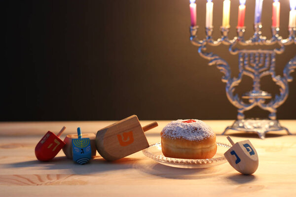 religion image of jewish holiday Hanukkah background with menorah (traditional candelabra), spinning top and doughnut