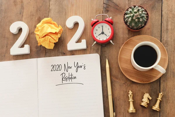 Biznesowa koncepcja top view 2020 roczna lista rozdzielczości z notatnikiem, filiżanka kawy nad drewnianym biurkiem — Zdjęcie stockowe