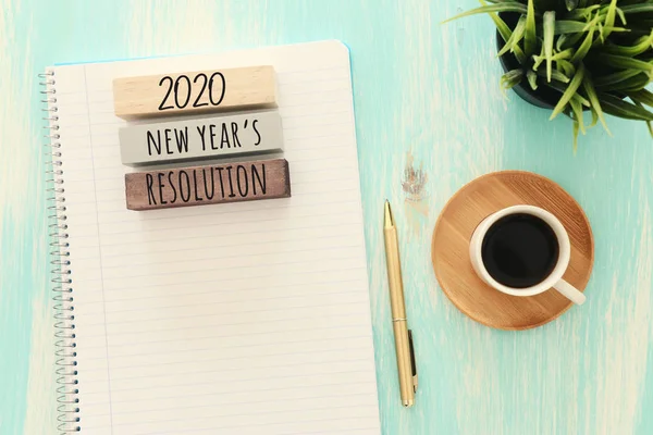 Biznesowa koncepcja top view 2020 roczna lista rozdzielczości z notatnikiem, filiżanka kawy nad niebieskim drewnianym biurkiem — Zdjęcie stockowe