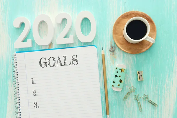 Obchodní koncept top view 2020 seznam cílů s notebookem, šálek kávy přes modrý dřevěný stůl — Stock fotografie