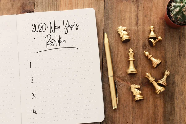 トップビューのビジネスコンセプト2020年の目標リストノートブック、木製の机の上のチェスの数字 — ストック写真