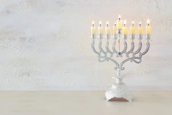 Θρησκευτική εικόνα της εβραϊκής διακοπές Hanukkah φόντο με μενόρα (παραδοσιακό κηροπήγιο) και κεριά πετρελαίου πάνω από λευκό φόντο — Φωτογραφία Αρχείου