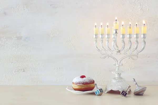 Religionsbild des jüdischen Feiertags Chanukka Hintergrund mit Kreisel und Donut über weißem Hintergrund — Stockfoto