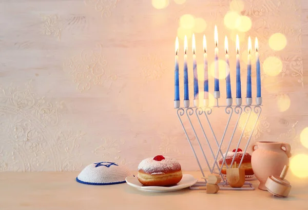 Imagen religiosa de vacaciones judías fondo Hanukkah con menorah (candelabros tradicionales), peonza y rosquilla sobre fondo pastel — Foto de Stock