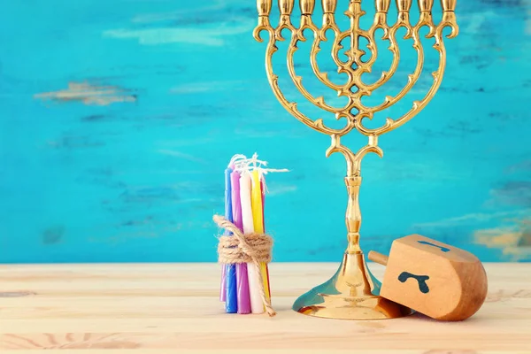 Religione immagine di festa ebraica Hanukkah con menorah (candelabro tradizionale) e trottola sopra tavolo di legno e sfondo blu — Foto Stock