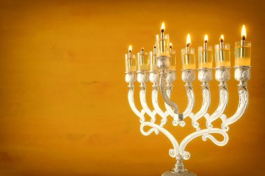 Yahudi bayramı Hanuka arkaplanının resmi menorah (geleneksel şamdan) ve sarı zemin üzerinde yağ mumları