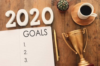 Üst görünüm iş konsepti 2020 gol listesi, not defteri, ahşap masa üzerinde bir fincan kahve