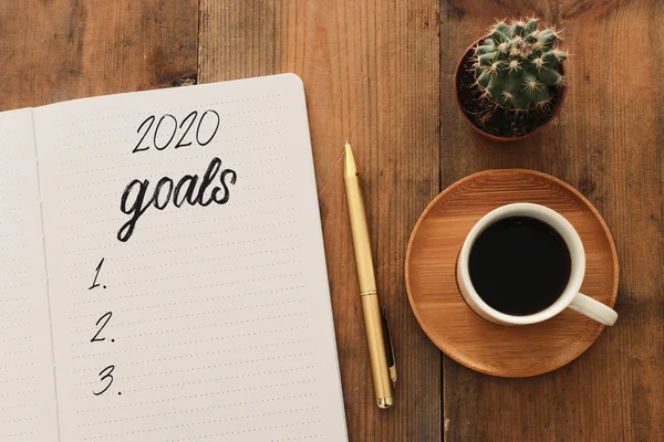 Zakelijk concept van top view 2020 doelen lijst met notebook, kopje koffie over houten bureau — Stockfoto