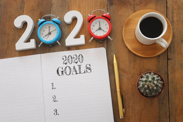 Επιχειρηματική έννοια της top view 2020 λίστα στόχων με σημειωματάριο, φλιτζάνι καφέ πάνω από το ξύλινο γραφείο — Φωτογραφία Αρχείου