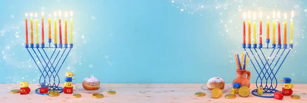 Релігійне зображення єврейського свята Ханука на фоні мелахи (традиційні канделябри), прядіння зверху та пончика — стокове фото