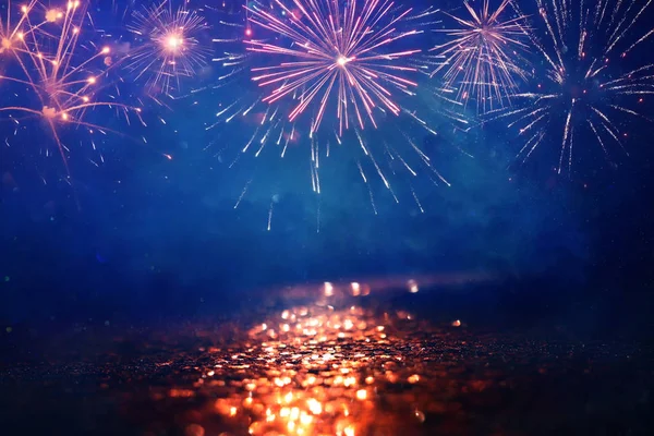 Elvont arany, fekete-kék csillogó háttér tűzijátékkal. Karácsony este, július 4. Ünnepi koncepció — Stock Fotó