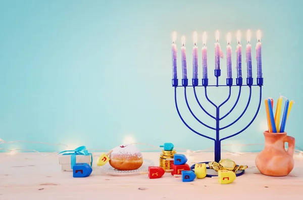 Imagen religiosa de vacaciones judías fondo Hanukkah con menorah (candelabros tradicionales), peonza y rosquilla sobre fondo pastel —  Fotos de Stock