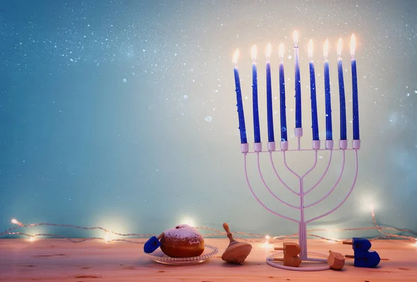 유대교 휴일 하누카 배경 과 메뉴라 ( 전통적 인 촛대 ) 가 위와 도넛 위에서 돌고 있는 모습 — 스톡 사진
