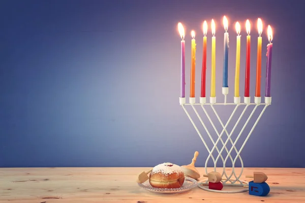 Θρησκευτική εικόνα της εβραϊκής διακοπές Hanukkah φόντο με μενόρα (παραδοσιακά κηροπήγια), περιστρεφόμενη κορυφή και ντόνατ — Φωτογραφία Αρχείου