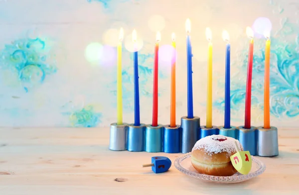 Imagen religiosa de vacaciones judías fondo Hanukkah con menorah (candelabros tradicionales), peonza y rosquilla sobre fondo pastel — Foto de Stock