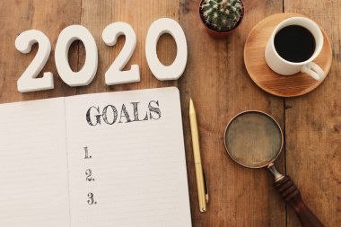 Üst görünüm iş konsepti 2020 gol listesi, not defteri, ahşap masa üzerinde bir fincan kahve