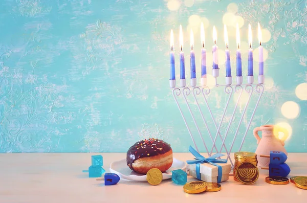 Religie beeld van joodse vakantie Chanoeka achtergrond met menorah (traditionele kandelaar), spinnen top en donut over pastel blauwe achtergrond — Stockfoto