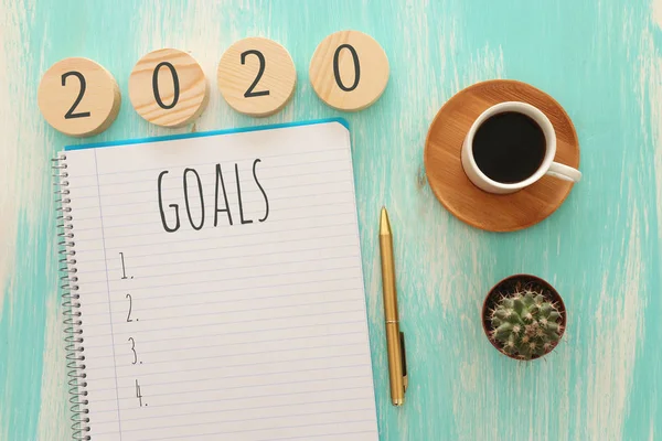 Biznesowa koncepcja top view 2020 lista celów z notebooka, filiżanka kawy nad drewnianym biurkiem — Zdjęcie stockowe