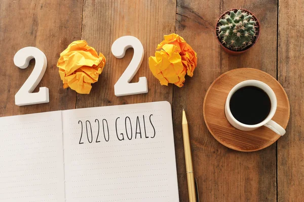 Obchodní koncept top view 2020 seznam cílů s notebookem, šálek kávy přes dřevěný stůl — Stock fotografie