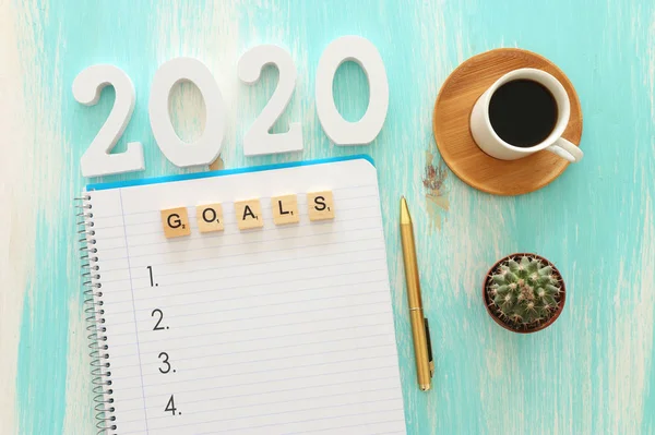 Obchodní koncept top view 2020 seznam cílů s notebookem, šálek kávy přes dřevěný stůl — Stock fotografie
