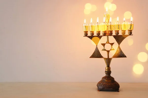 Imagen religiosa de la fiesta judía fondo de Hanukkah con menorah estrella de David de bronce (candelabros tradicionales) y velas de aceite —  Fotos de Stock