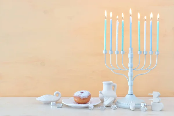 Θρησκευτική εικόνα της εβραϊκής διακοπές Hanukkah φόντο με μενόρα (παραδοσιακά κηροπήγια), περιστρεφόμενη κορυφή και ντόνατ — Φωτογραφία Αρχείου