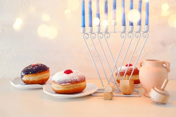 Religião imagem de feriado judaico Hanukkah fundo com menorah (candelabro tradicional), spinning top e donut sobre fundo pastel — Fotografia de Stock