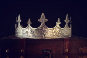 alacsony kulcs kép gyönyörű királynő / király korona felett fa asztal. vintage szűrt. fantasy középkori időszak