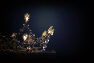 Tahta masanın üzerindeki güzel kraliçe ve kral tacının gösterişsiz görüntüsü. v