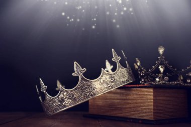 Eski kitap ve ahşap masa üzerinde güzel kraliçe / kral tacının gösterişsiz görüntüsü. Eski model filtrelenmiş. fantezi ortaçağ dönemi