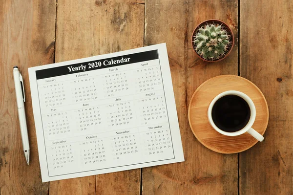 Conceito de negócio de vista superior 2020 lista de planos com notebook, xícara de café sobre mesa de madeira azul — Fotografia de Stock