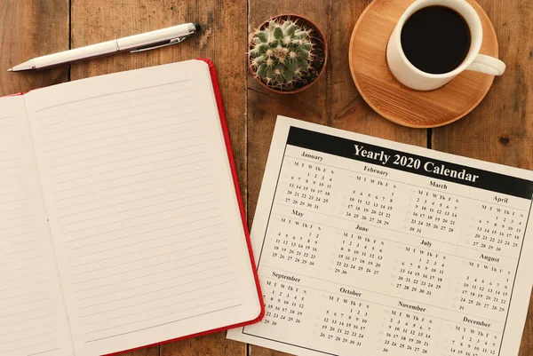 Affärsidé av top view 2020 plan lista med anteckningsbok, kopp kaffe över blå trä skrivbord — Stockfoto