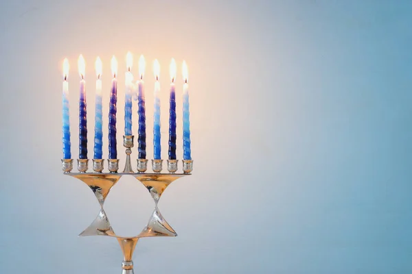 Religion image of jewish holiday Hanukkah background with david star menorah (traditional candelabra) and candles — Stock Photo, Image