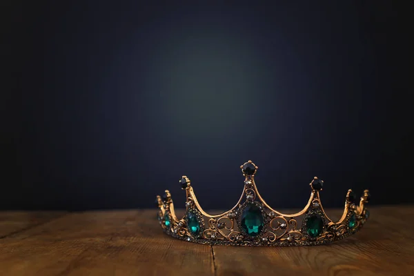 Niski kluczowy obraz pięknej królowej / korony króla nad drewnianym stołem. vintage filtrowane. okres średniowiecza fantasy — Zdjęcie stockowe