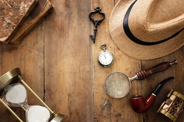 Imagem conceitual de investigação ou detetive particular. Chapéu Fedora, lupa e itens vintage sobre mesa de madeira — Fotografia de Stock