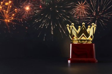 Tahta masanın üzerinde altın taç resmi.