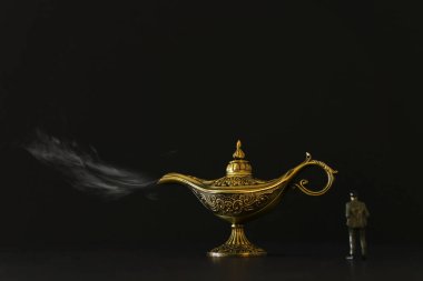 Aladdin lambası dumanla bakarken, dilek isteyen bir işadamının konsept resmi
