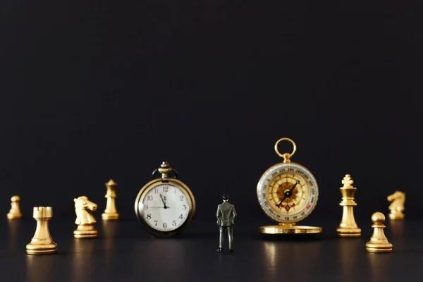 Imagen del juego de ajedrez. Hombre de negocios mirando reloj vintage, brújula y peones, competencia, estrategia, liderazgo y concepto de éxito — Foto de Stock