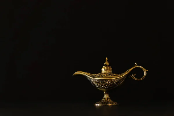Изображение волшебной таинственной лампы Аладдина с блестками сверкающего дыма на черном фоне. Лампа желаний — стоковое фото