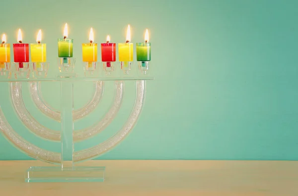 Kép a zsidó ünnep a Hanukkah háttérrel, crystal menorah (hagyományos kandeláberek) és a színes olaj gyertya — Stock Fotó