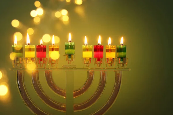 image of jewish holiday Hanukkah background with crystal menorah (traditional candelabra) and colorful oil candles