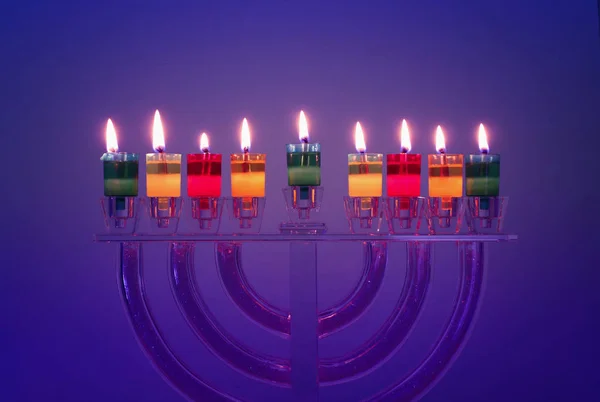 Image of jewish holiday Hanukkah background with crystal menorah (traditional candelabra) and colorful oil candles — Stock Photo, Image