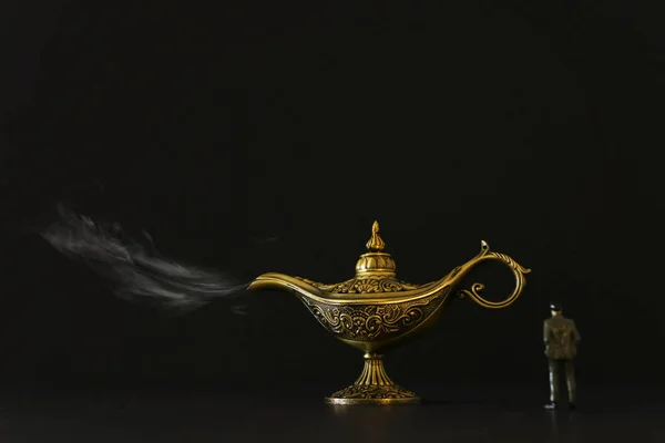 Concept foto van een zakenman kijkend naar Aladdin lamp met rook, vragen om een wens — Stockfoto