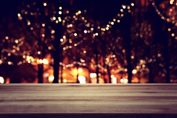 Background Image of wooden table in front of street view in front of abstract blurred lights — 스톡 사진