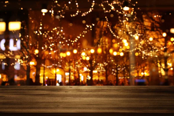 Background Image of wooden table in front of street view in front of abstract blurred lights — 스톡 사진